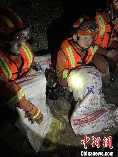 短暫修整期間，消防員脫掉鞋襪，用編織袋套住腿腳保暖。　閆旭輝 攝