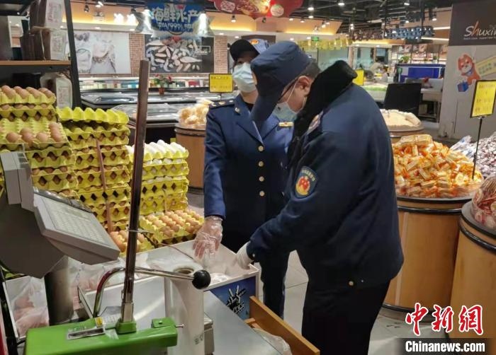 圖為疫情期間，甘肅嘉峪關(guān)市場監(jiān)管局工作人員檢查蔬菜市場。　 柴佳楠 　攝