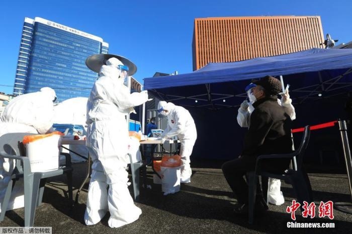 資料圖：韓國首爾，醫(yī)務人員對市民進行新冠病毒檢測。