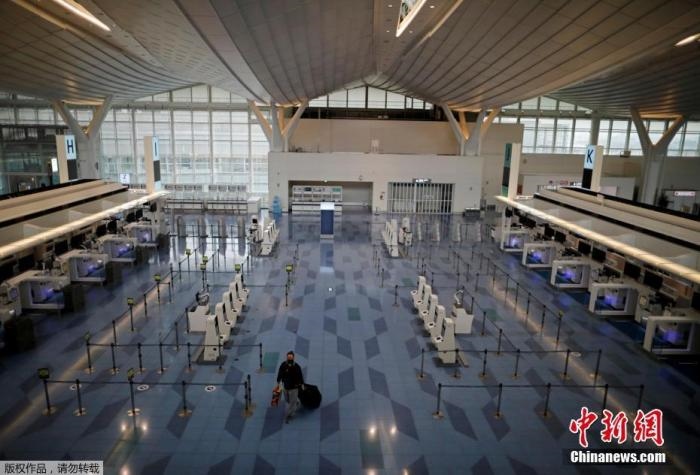 資料圖：日本東京，東京國際機(jī)場，一名乘客在國際航班航站樓的登機(jī)區(qū)。