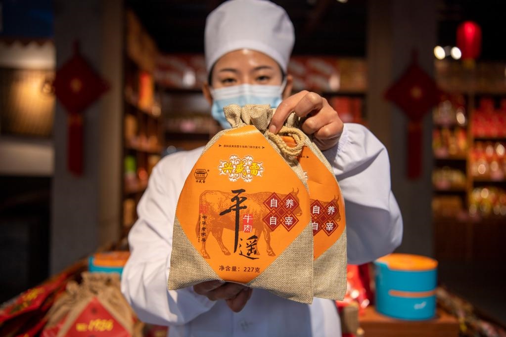 1月27日，在平遙古城南大街的一家平遙牛肉店內(nèi)，工作人員展示一款牛肉產(chǎn)品。新華社記者 楊晨光 攝