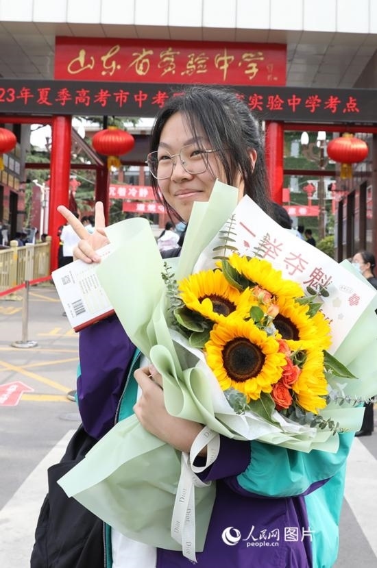 6月7日高考首日，山東67萬考生走進(jìn)考場，拼搏逐夢。在山東省實(shí)驗(yàn)中學(xué)考點(diǎn)，考生進(jìn)考場前手捧向日葵花拍照留念，寓意“一舉奪魁”。人民網(wǎng)記者 劉祺攝