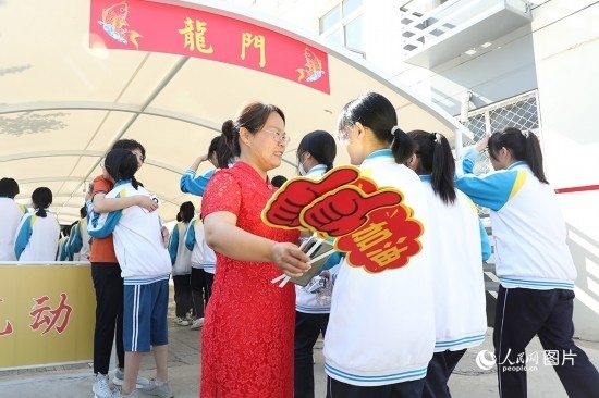 6月7日一早，雄安新區(qū)安新中學(xué)老師在給同學(xué)們加油鼓勁兒。人民網(wǎng) 李兆民攝