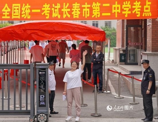 6月7日，在長春市第二中學(xué)考點(diǎn)，一名考生信心滿滿進(jìn)入考場，并與家長揮手致意。人民網(wǎng)記者 李洋攝