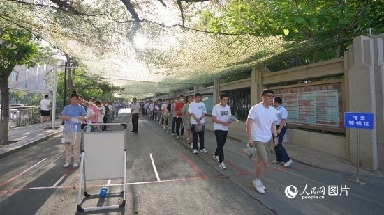 6月7日，烏魯木齊市第七十中學(xué)門口，考生們有序進(jìn)入考場。人民網(wǎng) 李欣洋攝