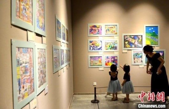 圖為家長帶著孩子參觀展覽。呂明 攝