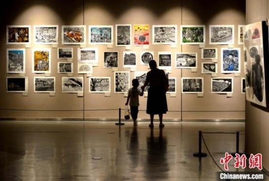 圖為家長帶著孩子參觀展覽。呂明 攝