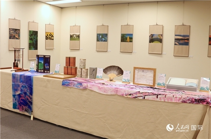 現(xiàn)場(chǎng)展出的馮學(xué)敏攝影作品與湖州市特色工藝品。（人民網(wǎng) 許可攝）