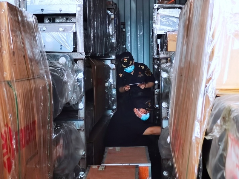 關(guān)員利用工業(yè)內(nèi)窺鏡在集裝箱內(nèi)進(jìn)行查驗(yàn)。人民網(wǎng)記者 栗翹楚攝