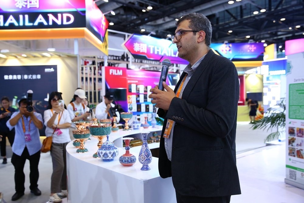 9月1日，參展商在國家會議中心向媒體記者介紹展臺信息。新華社記者 孫瑋彤 攝