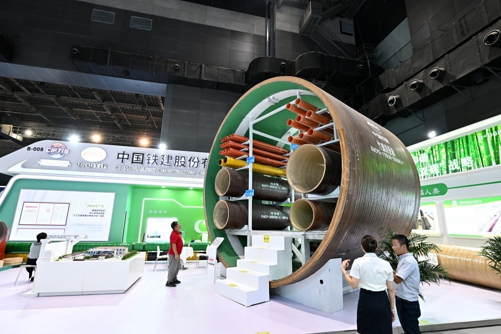 9月2日，在國家體育館舉行的服貿(mào)會(huì)環(huán)境服務(wù)專題展上，客商在中國鐵建展位竹纏繞管廊旁了解信息。新華社記者 李鑫 攝