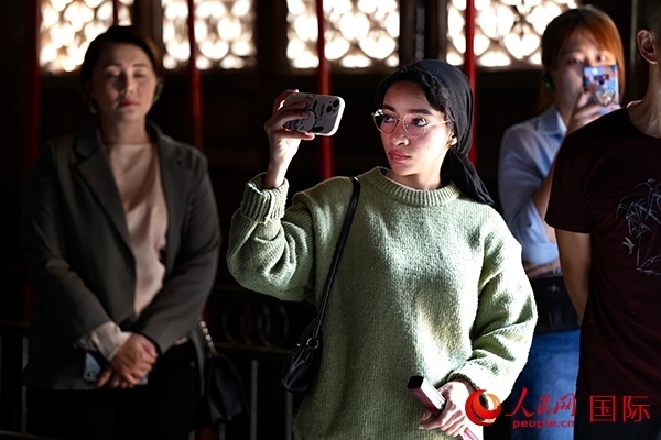 選手顏青（蘇丹）用手機記錄所見所感。人民網(wǎng) 盧鵬宇攝