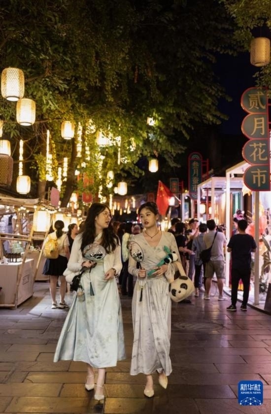 在成都寬窄巷子，兩位來(lái)自安徽的游客在新“十二月市”街區(qū)游覽（9月29日攝）。