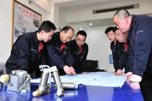 △李志強(qiáng)（左二）與班組成員在研究工作。