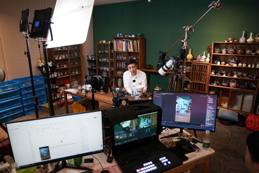 ↑在景德鎮(zhèn)，工作人員通過(guò)網(wǎng)絡(luò)直播推介陶瓷產(chǎn)品（2023年2月22日攝）。