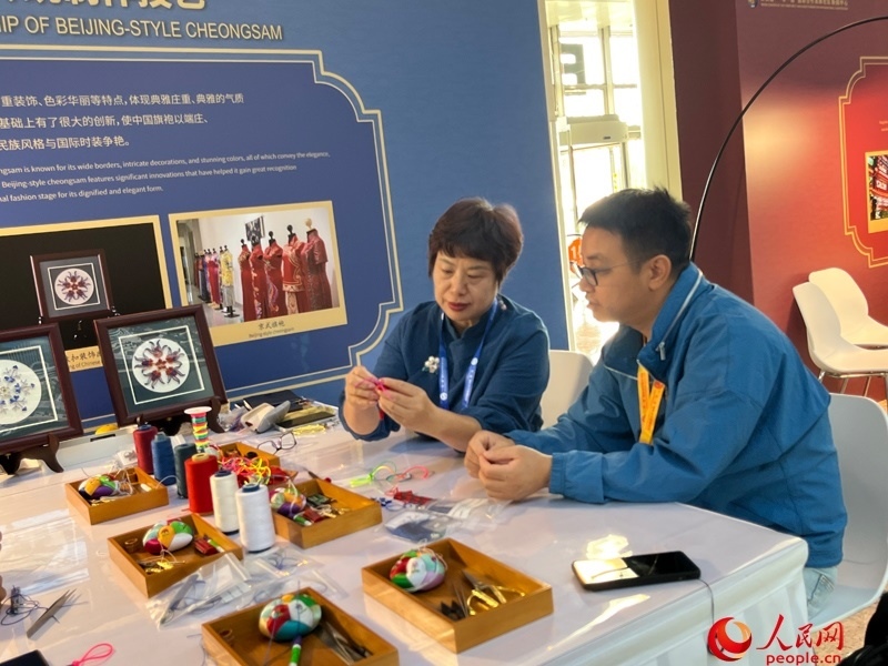 記者在新聞中心非遺傳承人展區(qū)進(jìn)行體驗(yàn)。人民網(wǎng)記者 杜燕飛攝