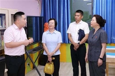 圖③：“小公民法律課堂”開講前，全國(guó)人大代表殷其龍（右二）、重慶市人大代表李自玲（左二）聽取楊家坪中學(xué)負(fù)責(zé)人關(guān)于未成年人思想教育工作情況的介紹。