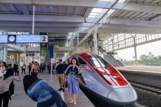 10月17日，在印度尼西亞萬隆德卡魯爾站，乘客在站臺上和雅萬高鐵高速動車組列車合影。新華社記者 徐欽 攝