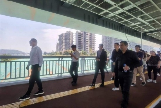 10月24日，2023“一帶一路”媒體合作論壇聯(lián)合采訪團(tuán)團(tuán)員走在清水塘大橋景觀通道上。本報(bào)記者 常雯宜攝