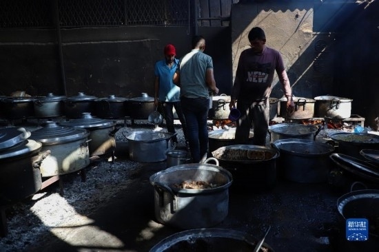 11月3日，在加沙地帶南部城市拉法，人們?cè)诿簹庵袛嗪笥貌窕鹱鲲?。新華社發(fā)（里澤克·阿卜杜勒賈瓦德攝）