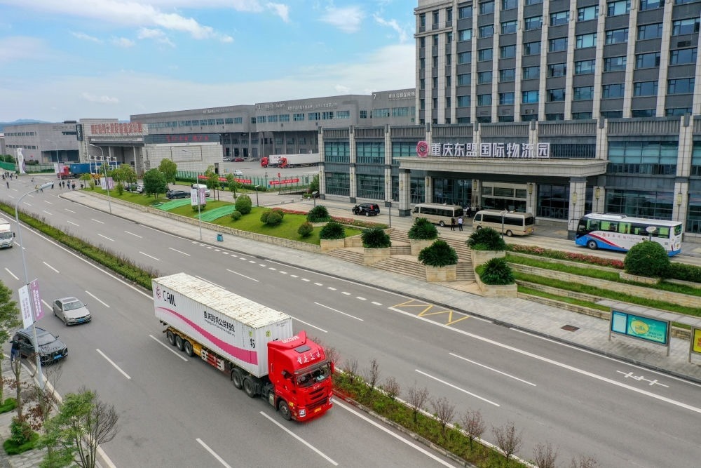 2023年10月11日，滿載筆記本電腦配件、發(fā)電機(jī)組件等產(chǎn)品的西部陸海新通道跨境公路班車從重慶南彭公路保稅物流中心駛出，將途經(jīng)廣西憑祥，直達(dá)越南（無(wú)人機(jī)照片）。新華社記者 黃偉 攝