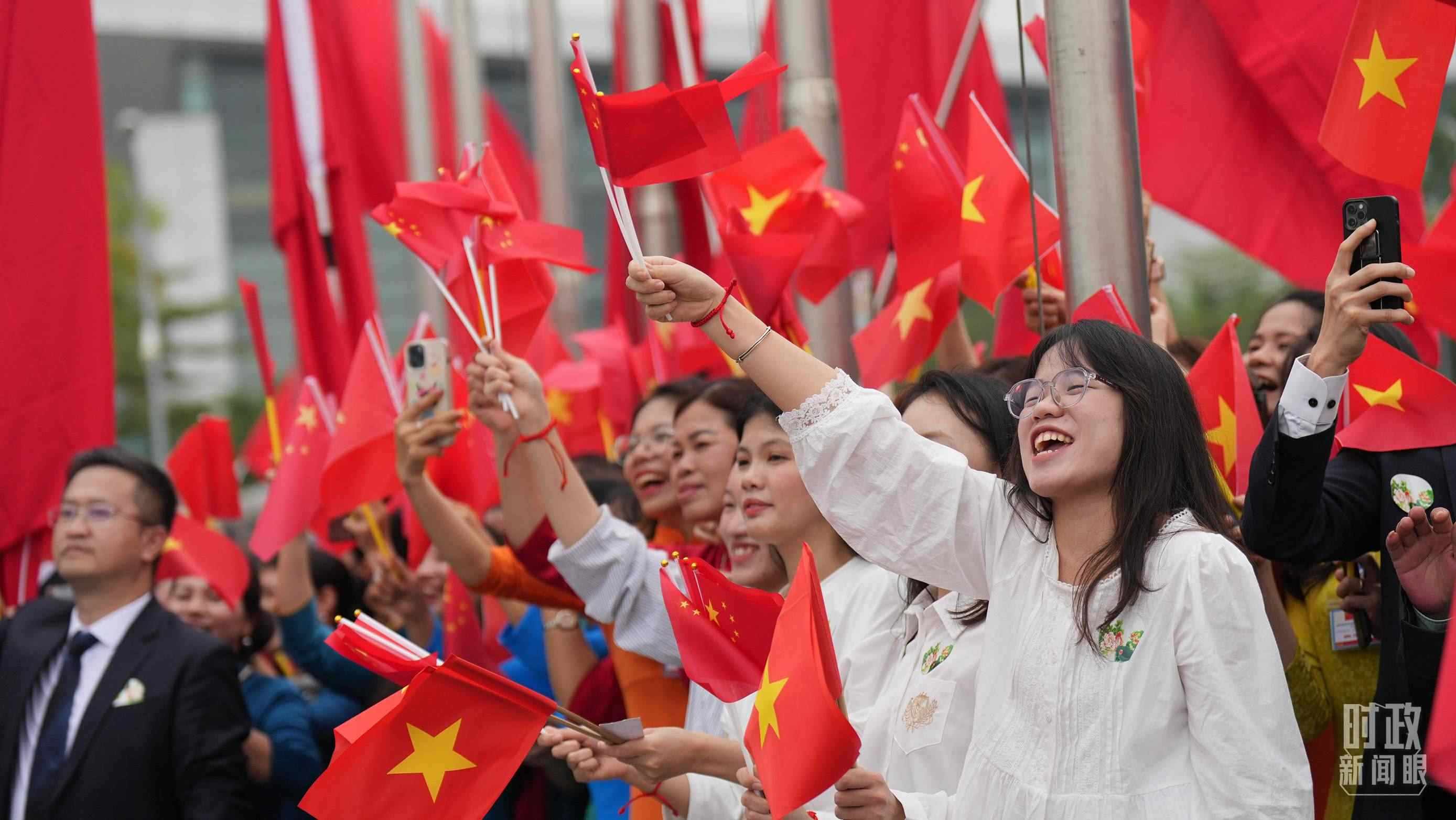 △人們揮舞兩國旗幟歡迎習近平訪越。（總臺國廣記者李晉拍攝）