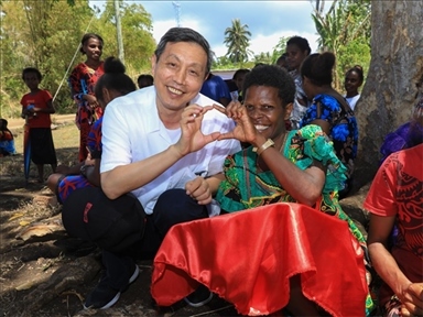 2023年12月18日，中國(guó)駐瓦努阿圖大使李名剛和前來觀看瓦努阿圖公路項(xiàng)目二期馬勒庫拉段移交儀式的當(dāng)?shù)鼐用窈嫌?。人民網(wǎng) 賀吉攝