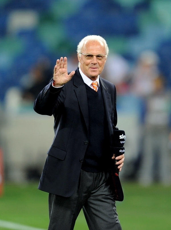 這是2010年7月7日，在南非德班舉行的2010年足球世界杯德國隊對陣西班牙隊的半決賽前，貝肯鮑爾接受電視臺采訪時和友人打招呼。新華社記者 王毓國 攝