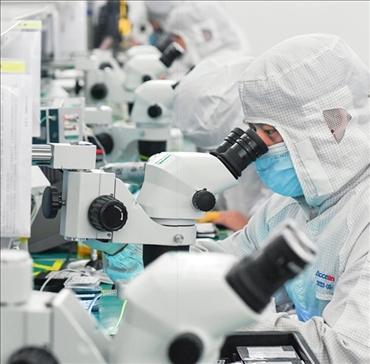 在位于武漢中國光谷的光電器件研發(fā)制造商——武漢光迅科技股份有限公司生產(chǎn)車間內，技術人員在光模塊生產(chǎn)線作業(yè)（2023年4月11日攝）。程敏攝/本刊