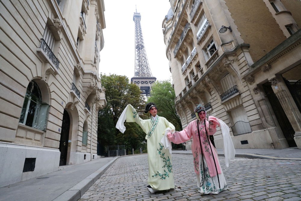 2023年9月13日，江蘇省演藝集團昆劇院院長施夏明（左）和江蘇省演藝集團昆劇院國家一級演員孔愛萍在法國巴黎埃菲爾鐵塔附近參加昆曲快閃。新華社記者 高靜 攝