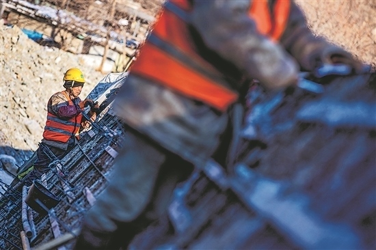 1月3日，房山區(qū)，工人正在雙泉河修筑堤壩。