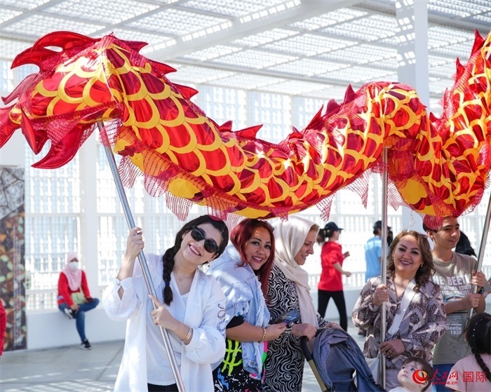 游客體驗舞龍。 人民網(wǎng) 塔里克·易卜拉欣攝