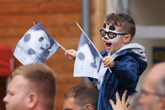  2023年7月26日，在法國(guó)圣艾尼昂市博瓦勒野生動(dòng)物園外，一名兒童等待送別熊貓“圓夢(mèng)”。新華社記者 高靜 攝