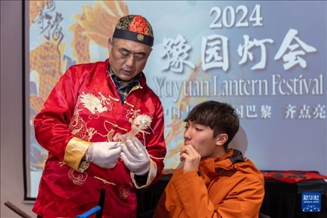 1月28日，在上海豫園舉行的民俗活動(dòng)上，美國(guó)馬斯卡廷中學(xué)學(xué)生在非遺傳承人的指導(dǎo)下吹糖偶。 新華社記者 王翔 攝