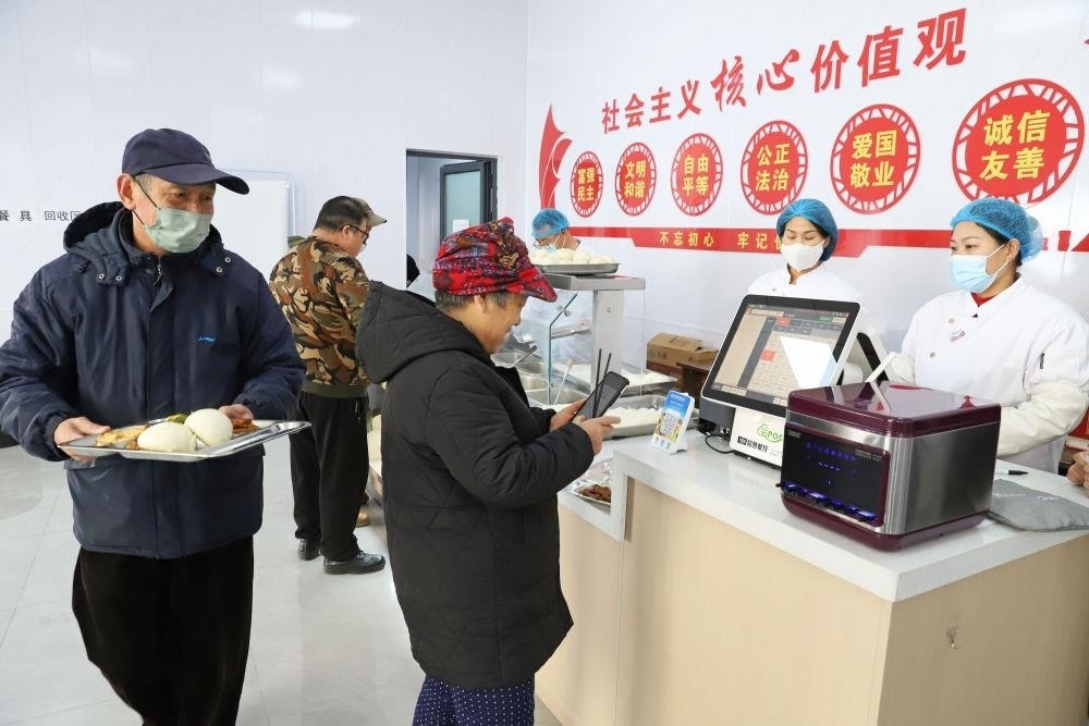 △2024年2月1日，市民在河北涿州市雙塔街道永濟秀園小區(qū)便民食堂內(nèi)購買午餐。