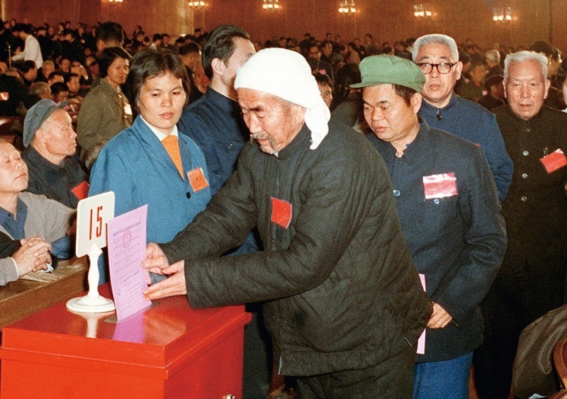 我國現(xiàn)行憲法于1982年12月4日由第五屆全國人大第五次會議通過并公布施行。根據(jù)改革開放和社會主義現(xiàn)代化建設(shè)的實踐和發(fā)展，全國人大于1988年、1993年、1999年、2004年、2018年先后5次作出必要的、也是十分重要的修正。圖為出席第五屆全國人民代表大會第五次會議的代表投票表決《中華人民共和國憲法》（資料照片）。 新華社發(fā)