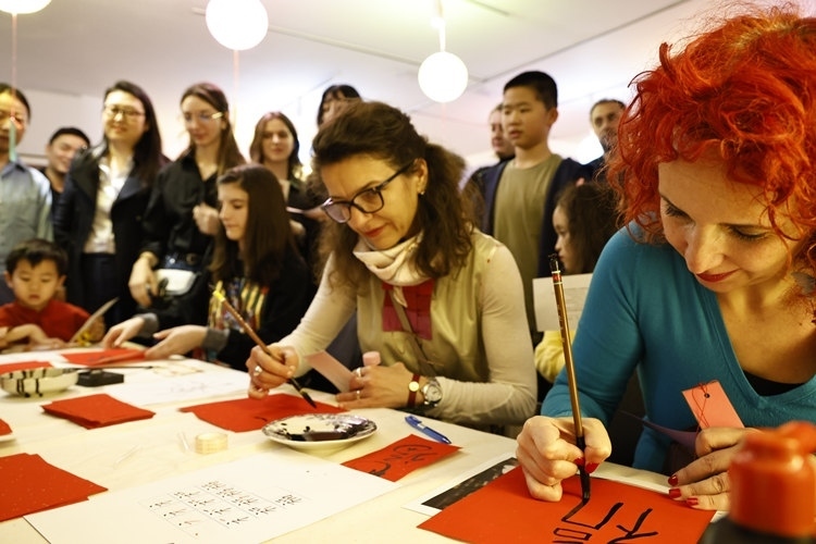 羅馬尼亞觀眾學(xué)習(xí)用毛筆寫“?！弊?。中國(guó)文化中心供圖