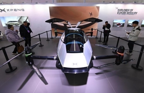 2023年12月1日，在鏈博會智能汽車鏈展區(qū)小鵬汽車展臺，參觀者觀看一臺智能飛行器。新華社記者蔡湘鑫攝