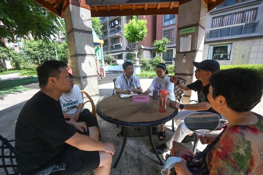 △2023年7月21日，在位于浙江杭州臨安區(qū)錦南街道水岸陽光小區(qū)的陽光議事廳，街道干部在聽取居民們反映的問題及意見。