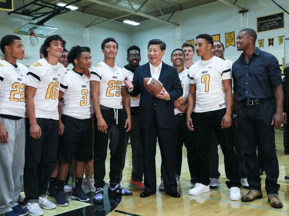 2015年9月23日，國(guó)家主席習(xí)近平參觀美國(guó)塔科馬市林肯中學(xué)。這是習(xí)近平在學(xué)校體育館，同上橄欖球訓(xùn)練課的學(xué)生們親切交談。新華社記者 蘭紅光 攝