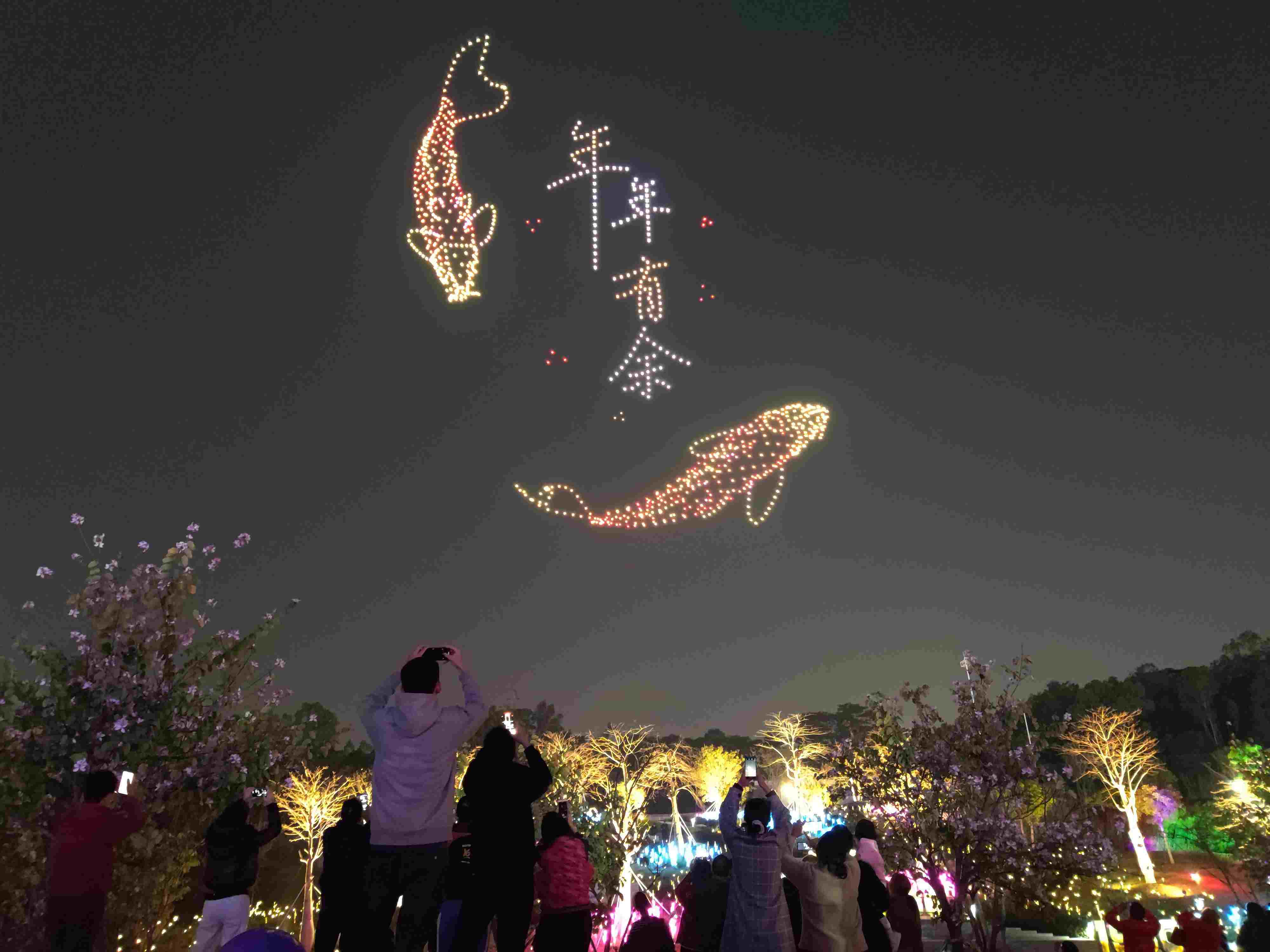 △ 2024年2月10日，深圳北站中心公園，春節(jié)主題無(wú)人機(jī)燈光秀引來(lái)眾多游客駐足觀看。