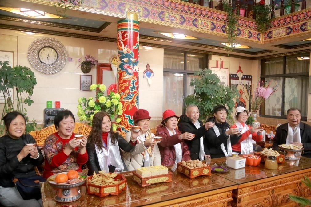 游客們?nèi)胱∶袼藓?，舉杯共飲酥油茶。新華社記者 邱星翔 攝