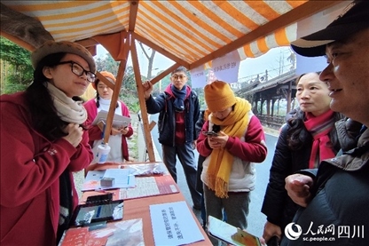 1月6日，“2024成都蒲江柑甜采摘節(jié)”上，記者見到了小萌（左一）和許多年輕人忙著做訪客接待、現(xiàn)場布置、票務(wù)核對(duì)、采摘服務(wù)等工作。人民網(wǎng)記者朱虹攝