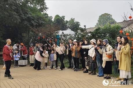 葉科（左一）給前來參與活動(dòng)的“柑爸柑媽”介紹生態(tài)種植果。人民網(wǎng)記者朱虹攝