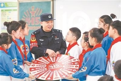 圖為公安民警給學(xué)生們講解國家安全知識(shí)。張鷹攝