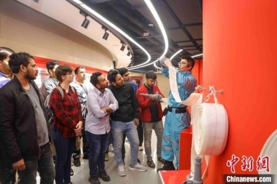 5月9日，工作人員指導(dǎo)留學(xué)生正確使用消防水帶。張鷹 攝