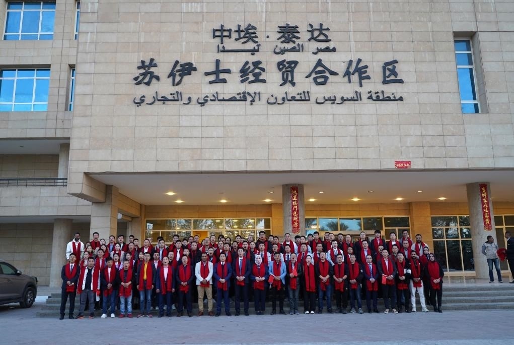 2024年2月11日，在位于埃及蘇伊士省的中?！ぬ┻_蘇伊士經(jīng)貿(mào)合作區(qū)，中埃員工在合作區(qū)辦公大樓前合影拜年。新華社發(fā)（泰達合作區(qū)供圖）