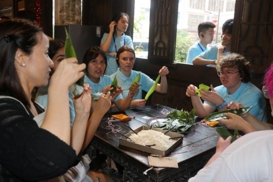 6月9日，美國(guó)青年代表在重慶永川松溉古鎮(zhèn)體驗(yàn)包粽子。新華社記者 周思宇 攝