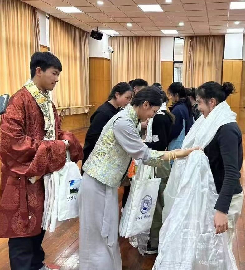 2024年1月18日，在上海市大同中學(xué)，果洛西寧民族中學(xué)學(xué)生給上海大同中學(xué)師生獻哈達。新華社發(fā)（果洛州教育局供圖）
