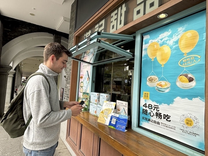 來自德國(guó)的留學(xué)生理查德在杭州西湖邊一家商鋪使用支付寶掃碼支付（2024年4月11日攝）。新華社發(fā)